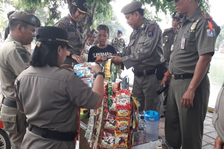Petugas Satpol PP mengamankan sebuah gerobak minuman yang terjaring razia di Danau Sunter Barat, Jakarta Utara, Kamis (27/9/2018).