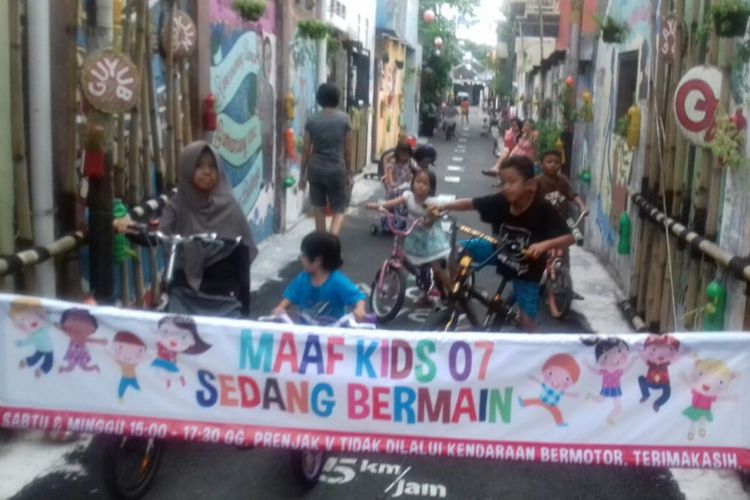 Anak-anak Kampung Joho bermain sepeda saat pintu masuk kampung ditutup setiap Sabtu-Minggu di Solo, Jawa Tengah.