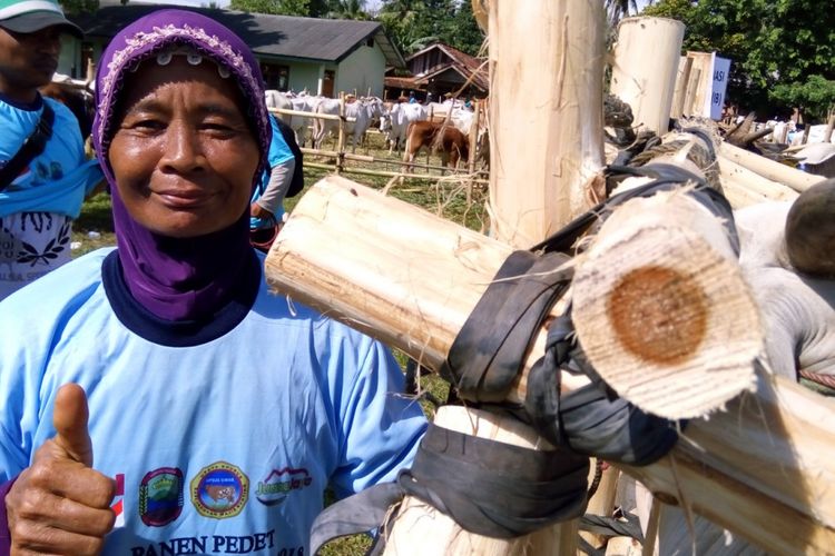 Suminem mengacungkan jempol tangan kanan saat sapi betina peliharaannya dipersiapkan untuk inseminasi buatan (IB) di Lapangan Simpang Empat, di Desa Neglasari, Kecamatan Ketibung, Kabupaten Lampung Selatan, Provinsi Lampung, Kamis (29/3/2018).