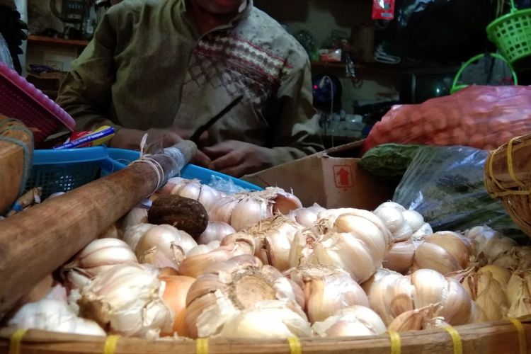 Salah seorang pedagang di Pasar Johar Karawang tengaj melayani pembeli bawang putih, Selasa (7/5/2019). Harga bawang putih di pasar ini mencapai Rp 65.000.

