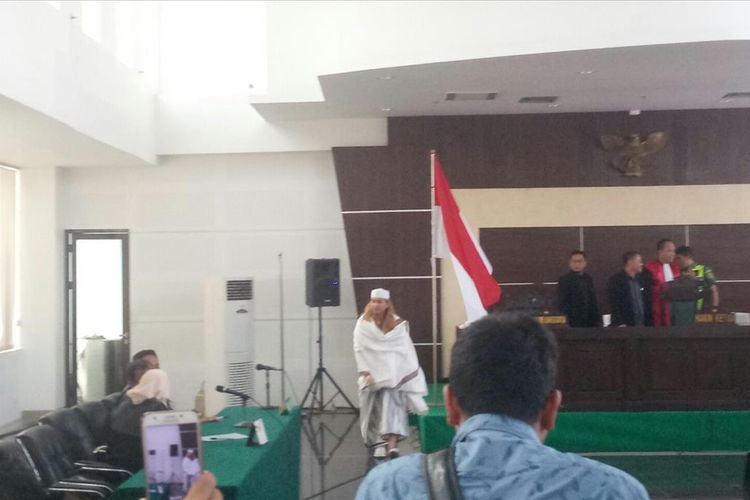 Bahar bin Smith berjalan usai mencium bendera merah putih setelah vonis tiga tahun yang dijatuhkan kepadanya, Selasa (9/7/2019).