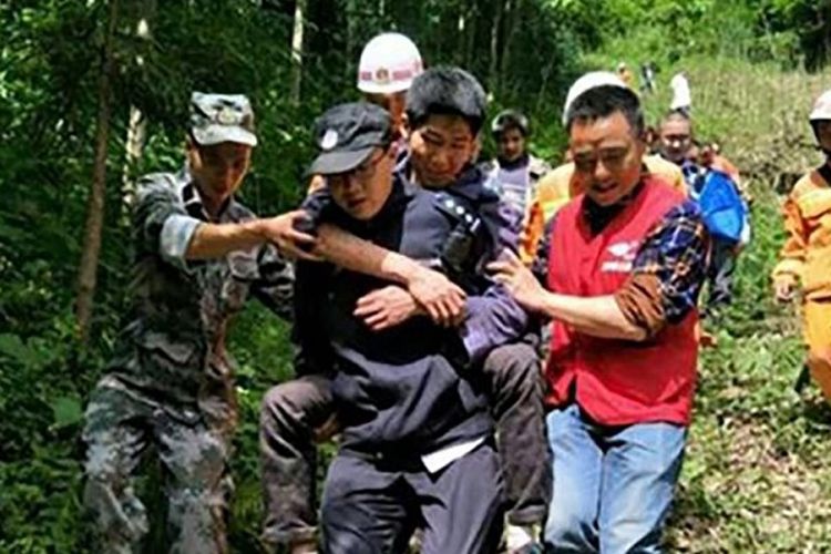 Petugas kepolisian menyelamatkan Zhou Bo. Pria 26 tahun yang ditemukan tersesat di gunung pada Sabtu (12/5/2018).