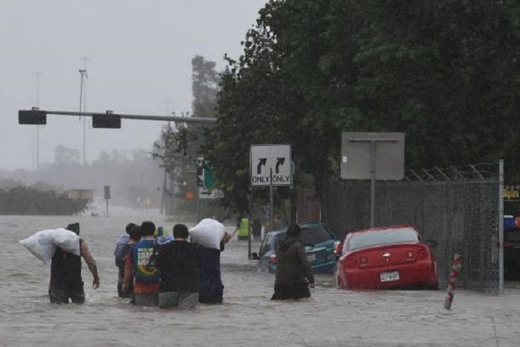 Warga mengevakuasi dirinya di Jalan Tol 90 di kota Houston setelah badai Harvey menimbulkan banjir dahsyat di kota terpadat di Texas tersebut.