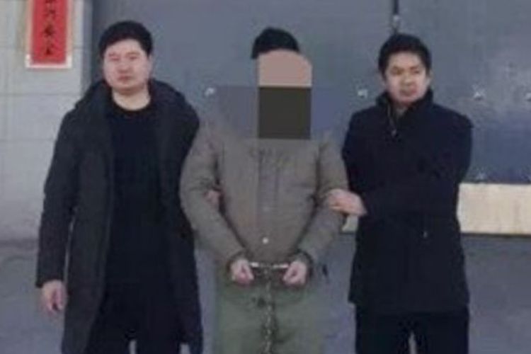 Polisi ketika menggiring Yang, seorang pria berusia 30 tahun yang melakukan tindak penipuan terhadap gadis yang dikenalnya di aplikasi pencari jodoh.