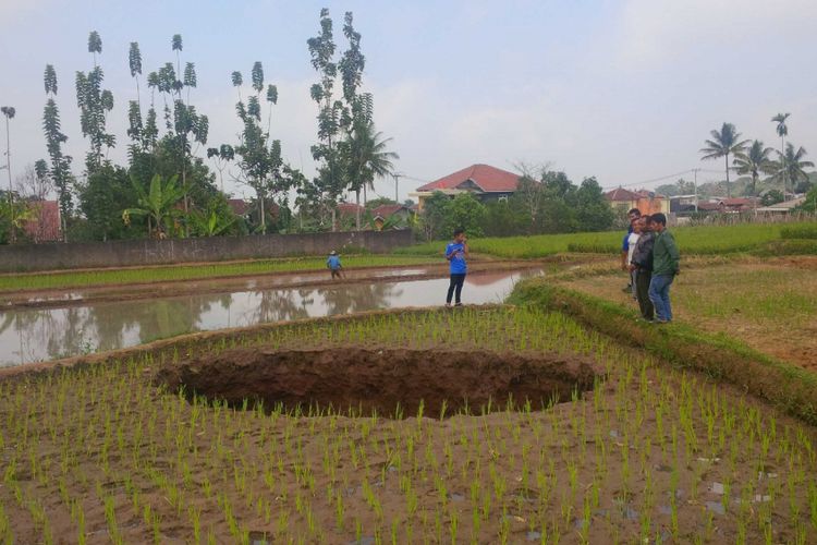 Sejumlah warga melihat tanah ambles berbentuk bulat di Kadudampit, Sukabumi, Jawa barat, Jumat (7/9/2018). 