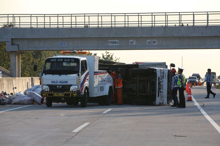 Truk terguling karena mengalami kecelakaan di ruas tol Solo - Ngawi kilometer 555, Ngawi, Jawa Timur, Jumat (24/5/2019). Kecelakaan yang mengakibatkan satu orang luka-luka ini disebabkan pecah ban.