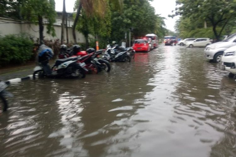 Halaman parkir gedung Samsat Jakarta Barat tergenang akibat saluran air di Jalan Daan Mogot meluber setelah hujan yang mengguyur wilayah tersebut pada Rabu (13/12/2018).