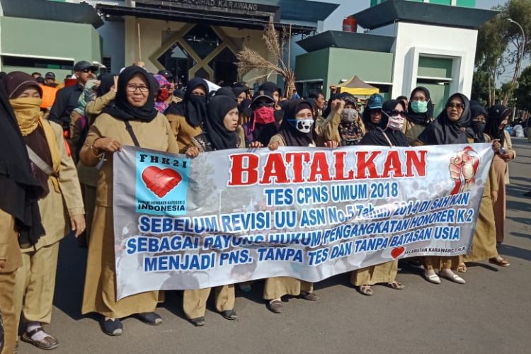 Ratusan honorer Kategori 2 di Karawang berunjuk rasa di depan Kantor Pemkab Karawang, Selasa (18/9/2018). Mereka menuntut Pemkab Karawang menolak seleksi CPNS 2018.