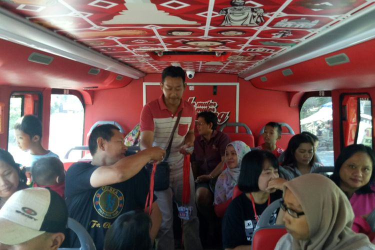 Petugas bus tingkat wisata Semarang sedang mengembalikan KTP penumpang yang ditukarkan dengan kartu tiket bus ini, Jumat (6/9/2017). Penukaran KTP dengan tiket bus wisata ini dilakukan saat sebelum masuk bus, dan sebelum sampai di pemberhentian terekhir.