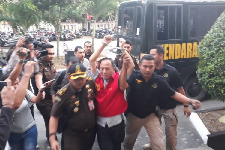 Conti Chandra saat diturunkan dari mobil tahanan dan digiring masuk ke dalam kantor Kejaksaan Negeri Batam.