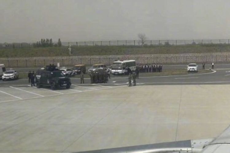 Personil darurat bersiap di landasan di Bandara Internasional Zhengzhou Xinzheng di Provinsi Henan, setelah sebuah pesawat mendarat darurat karena kasus penyanderaan, Minggu (15/4/2018).