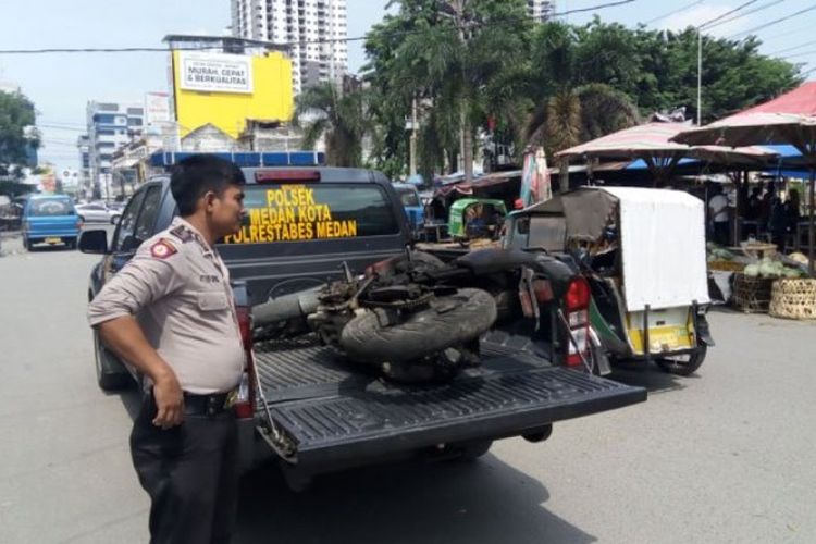 Petugas Polsek Medan Kota mengamankan barang bukti sepeda motor yang sempat dibakar salah satu massa di Jl Veteran, Medan, Selasa (5/9/2017).