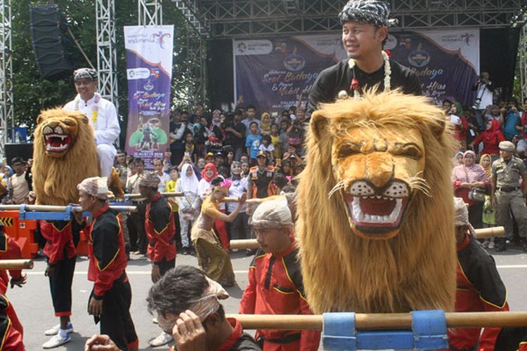 Wali Kota Bogor Bima Arya (kanan) mengikuti kesenian tradisional Sisingaan saat Festival Helaran Seni Budaya 2018 di Jalan Sudirman, Kota Bogor, Jawa Barat, Minggu (12/8/2018). Festival Helaran Seni Budaya 2018 yang merupakan puncak peringatan HUT ke-536 Kota Bogor, diikuti ribuan peserta dari berbagai Kota dan Kabupaten di Jawa Barat yang menjadi ajang promosi pariwisata dan budaya untuk meningkatkan jumlah kunjungan wisatawan ke Kota Bogor.