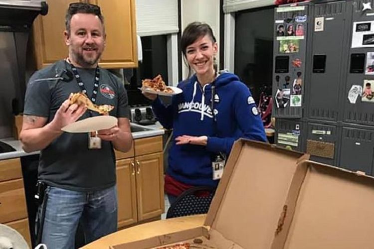 Petugas pengatur lalu lintas udara (ATC) di Portland, Amerika Serikat, David Heady dan Julie Lytle ketika menerima pizza dari koleganya ATC Kanada. ATC Kanada mengirim pizza setelah petugas ATC AS belum menerima gaji akibat terkena shutdown.