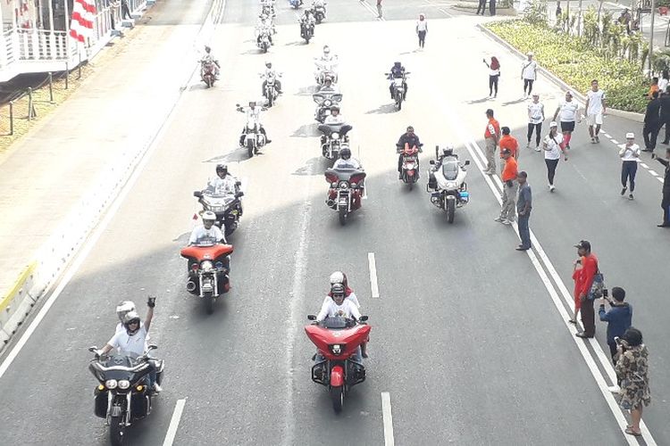 Komunitas motor gede merk Harley Davidson mengiringi torch relay atau kirab obor Asian Games 2018 pada Sabtu (18/8/2018) 