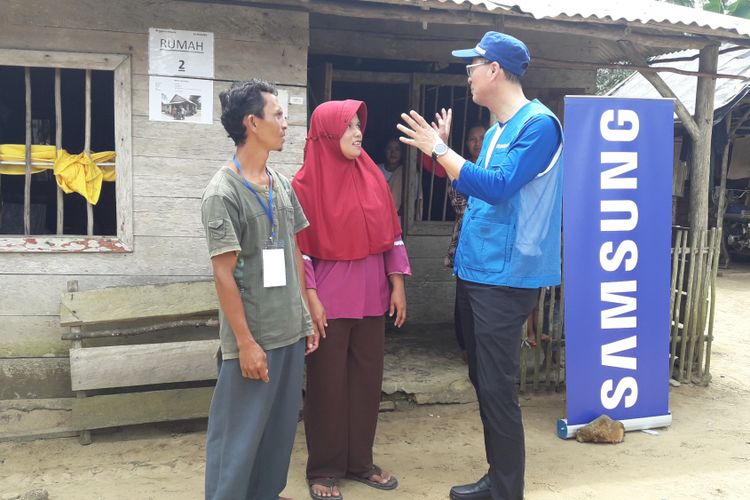 Vice President General Affairs Samsung Electronics Indonesia Kanghyun Lee bercengkerama dengan penerima manfaat program revitalisasi rumah layak huni, di Desa Penagan, Kabupaten Bangka, Provinsi Bangka Belitung, Selasa (7/11/2017).