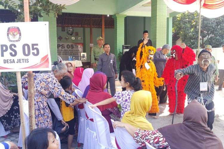 JOGET--Petugas TPS 05, Dusun Plaosan, Desa Jetis, Kecamatan Dagangan, Kabupaten Madiun berjoget mengenakan kostum dongkrek menghibur pemilih yang akan menggunakan hak pilihnya. 