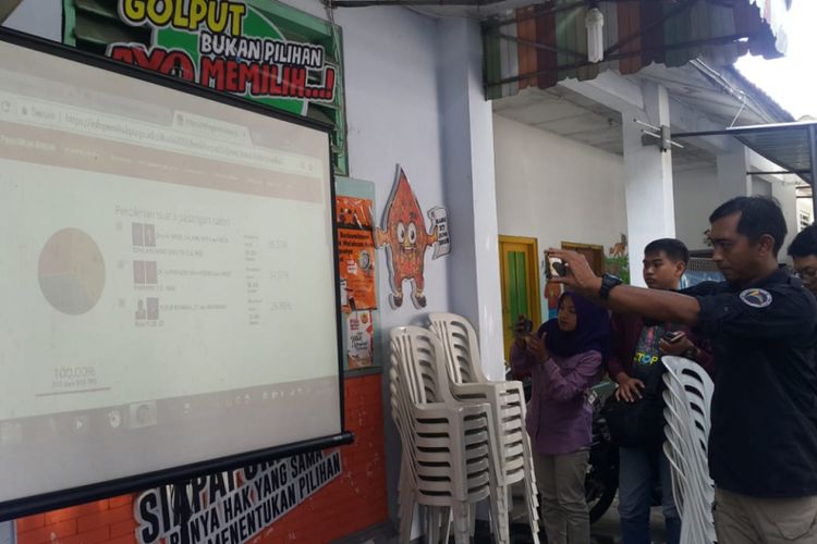  Warga mencari informasi perolehan suara perhitungan cepat KPU Kota Madiun untuk Pilkada Kota Madiun dan Pilkada Jatim 2018, Kamis ( 28/6/2018) siang.