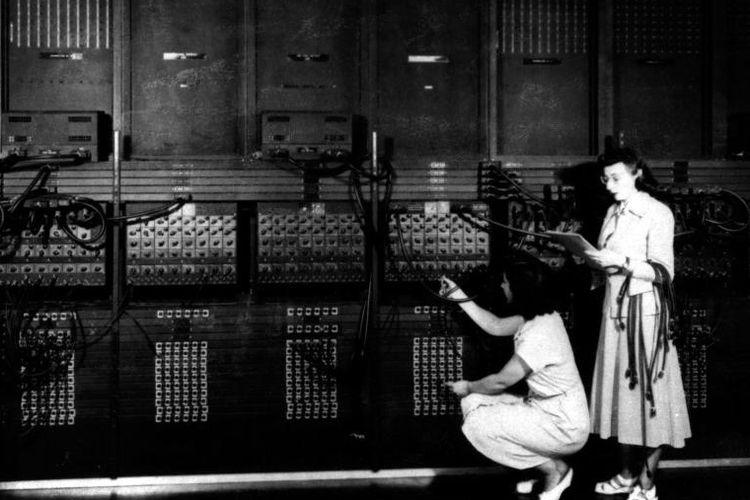 Dua pemrogram komputer wanita memasang sisi kanan Electronic Numerical Integrator and Computer, sebuah komputer elektronik umum untuk keperluan umum, dengan program baru.
SCIENCE HISTORY IMAGES, ALAMY