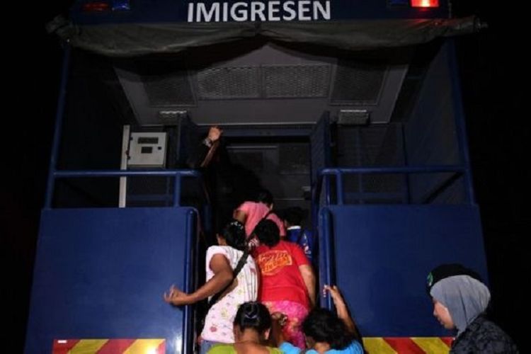 Sejumlah warga asing yang tidak membawa dokumen perjalanan atau membawa dokumen perjalanan palsu digiring ke dalam truk di Port Dickson, Malaysia, 7 Agustus.