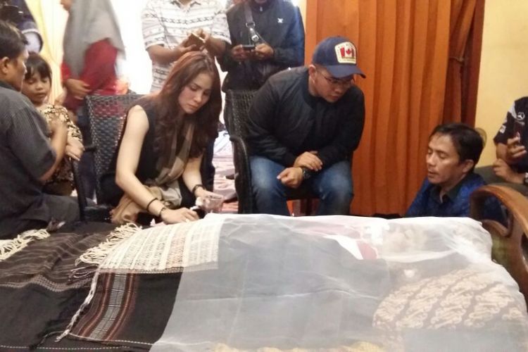 Momo Geisha duduk di samping jenazah ayahnya, Jabonar Sinaga, di Pekanbaru, Riau, Rabu (20/9/2017).