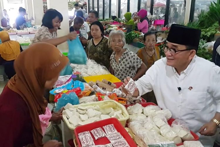 Juru Bicara Tim Kampanye Nasional (TKN) Jokowi-Maruf Amin, Ruhut Sitompul membeli tempe dan tahu milik pedagang Pasar Kadipolo, Kota Solo, Jawa Tengah, Jumat ( 16 / 11 / 2018) .
