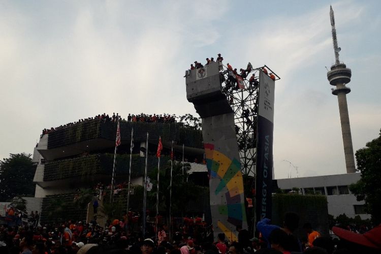 Suporter Persija Jakarta nekat memanjat dinding panjat tebing guna memyaksikan pertandingan Persija vs Mitra Kukar di Kantor Kemenpora, Minggu (9/12/2018).