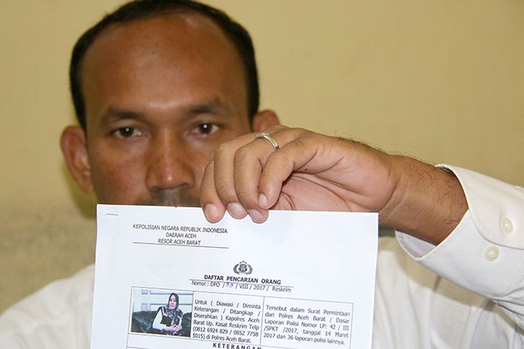 Anggota Satuan Reskrim Polres Aceh Barat memperlihatkan surat DPO terhadap Nazla Lubis Direktur Azizi Kencana Wisata Medan dalam kasus penggelapan uang perjalan calon jamah umrah, Rabu (06/09/17).  