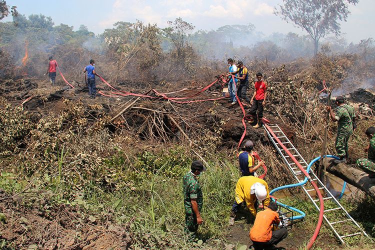 Petugas gabungan dari BPBD dan TNI melakukan upaya pemadaman titik api kebakaran hutan dan lahan gambut di kawasan Desa Peunaga Cut Ujong, Kecamatan Meureubo, Aceh Barat dengan cara menggunakan satu unit mesin pompa air dan armada kebakaran, Selasa (24/10/17)