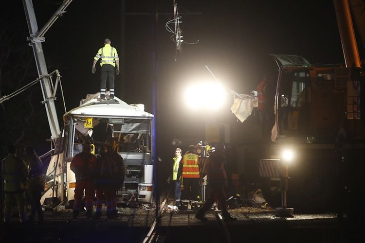 Petugas pemadam kebakaran dan polisi berada di lokasi kecelakaan di Millas, dekat Perpignan, Perancis selatan, pada Kamis (14/12/2017), setelah kereta menabrak bus sekolah. (AFP/Raymond Roig)
