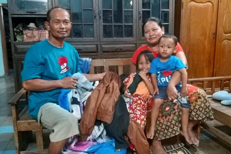 Arina Fitroh dan Arif menunjukkan baju, selimut dan jaket yang diberikan pasangan Nanda Sapto Wati dan Aiptu Sujadi setelah menyelamatkan keduanya bersama dua anaknya terjebak banjir di pinggir tol Ngawi-Kertosono di kediamannya pamannya di Magetan, Jumat (8/3/2019) malam. 