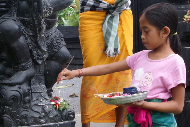 Seorang anak tengah beribadah di pura kecil yang dekat dengan tempat pengungsian. 