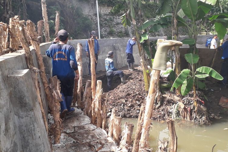 Petugas Suku Dinas Sumber Daya Air memperbaiki tanggul Jatipadang usah jebol, Selasa (2/4/2019).