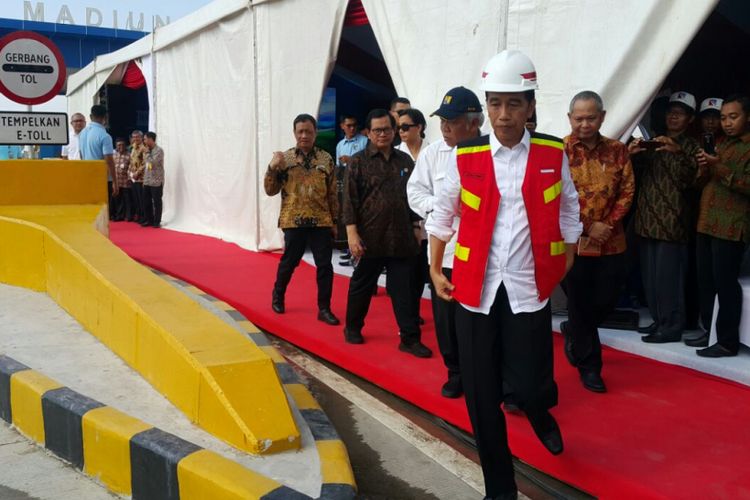 Presiden Jokowi mengenakan rompi sebelum mengecek kondisi ruas jalan tol Ngawi-Wilangan di Desa Bagi, Kabupaten Madiun, Jawa Timur, Kamis (29/3/2018) sore.