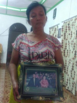 Dameria boru Sidabariba (52), saat menunjukkan foto suaminya, Hotman Nainggolan yang tenggelam di Dsnau Toba, Selasa (19/6/2018).