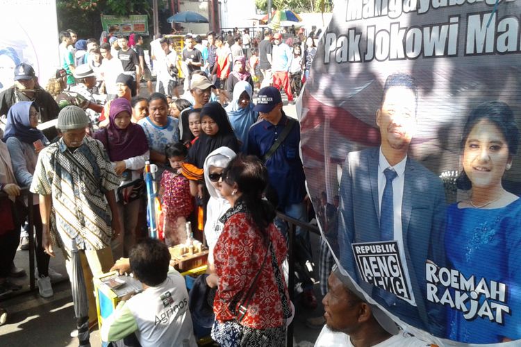 Pengunjung mengantre mendapatkan kue Putu Bambu dalam acara syukuran pernikahan putri Presiden Jokowi di car free day (CFD) Jl Slamet Riyadi Solo, Minggu (5/11/2017).