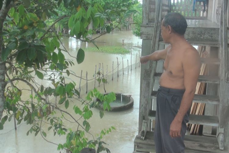 Nazarudin menunjukkan sumur yang ada di halaman rumahnya yang terendam banjir.  Akibat banjir Nazarudin dan keluarga kesulitan air bersih dan harus membeli air isi ulang dengan aharga Rp 6000 pergalon 