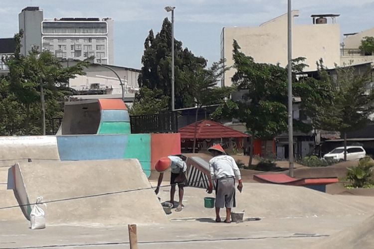 Dua orang pekerja tengah memperbaiki arena skateboard di Ruang Terbuka Hijau Kalijodo, Kamis (15/11/2018).
