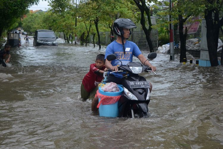 Pengendara melewati banjir di Jalan Pendidikan Makassar, Sulawesi Selatan, Selasa (22/01/2019). Akibat hujan deras dan angin kencang yang mengguyur Kota Makassar, sejumlah ruas jalan tergenang banjir. ANTARA FOTO/Sahrul Manda Tikupadang/ama.
