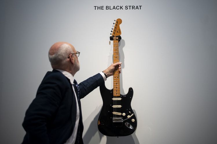 Spesialis Alat Musik dari rumah lelang Christies, Kerry Keane, memegang gitar  Black Strat (Fender Stratocaster, 1969) milik musisi David Gilmour yang dilelang di New York City, pada 14 Juni 2019.