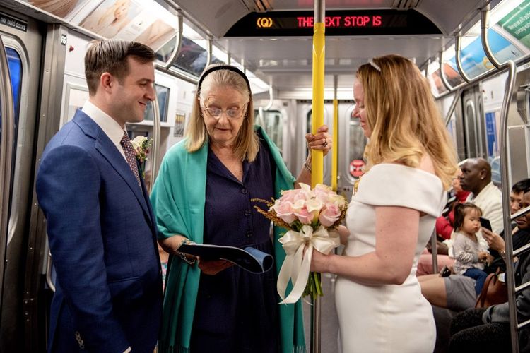 Robert Musso (30) dan Francis Denmark (32) saat akan mengucap janji pernikahan di atas kereta Q-Train yang melintasi Jembatan Manhattan, Sabtu (11/5/2019).