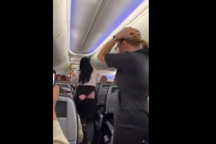 Potongan video memperlihatkan seorang perempuan melemparkan laptop kepada si pacar dalam penerbangan American Airlines dari Miami ke Los Angeles setelah perempuan itu menuduh si pacar melirik wanita lain.