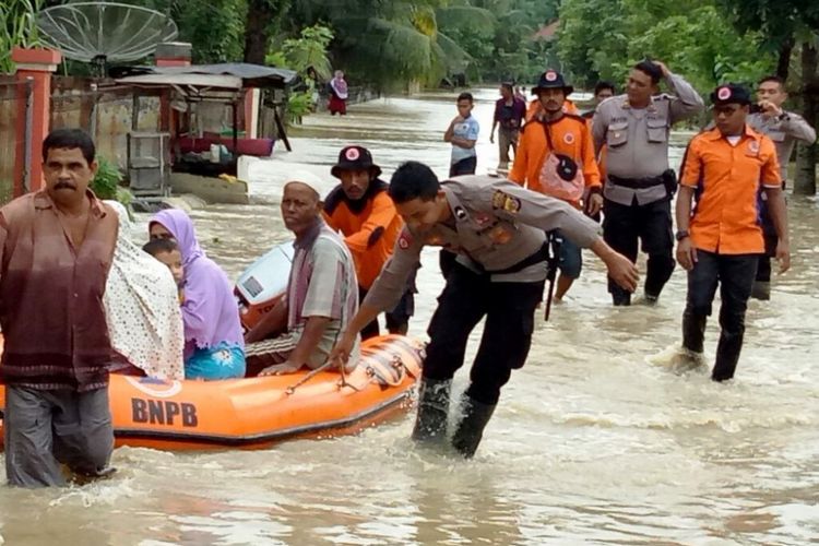 Polisi dan Tim BPBD Aceh Utara mengevakuasi korban banjir di Desa Hagu, Kecamatan Matangkuli, Aceh Utara, Sabtu (2/12/207). 