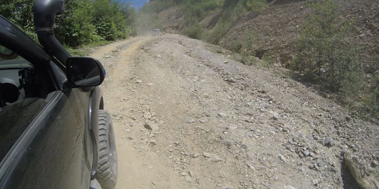 Mobil penggerak empat roda melewati jalan yang rusak di Pegunungan Arfak, Papua Barat, Kamis (16/8/2018). Akses jalan rusak menuju Pegunungan Arfak dari Manokwari adalah tantangan untuk pengembangan pariwisata Pegunungan Arfak.