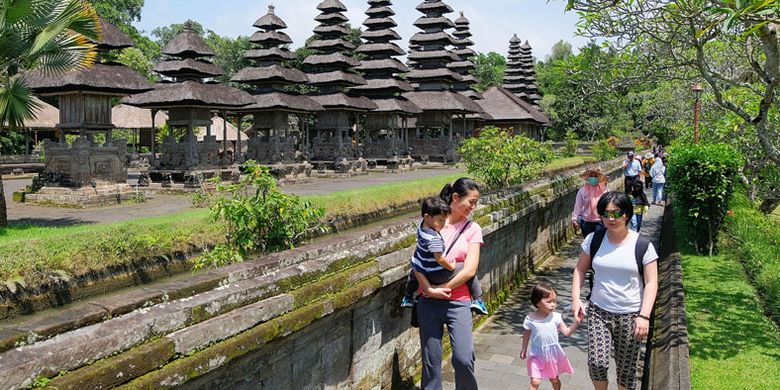 Wisatawan berjalan di kawasan Pura Taman Ayun, Badung, Bali, Jumat (14/12/2018). Wisatawan mancanegara yang datang ke Bali masih didominasi turis Cina yaitu mencapai 23,4 persen dari total wistawan yang berkunjung ke Pulau Dewata. 