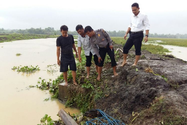 Petugas Polsek Kroya dan warga mengecek lokasi pintu air Sungai Tengah, Cilacap, Jawa Tengah, Senin (16/10/2017).