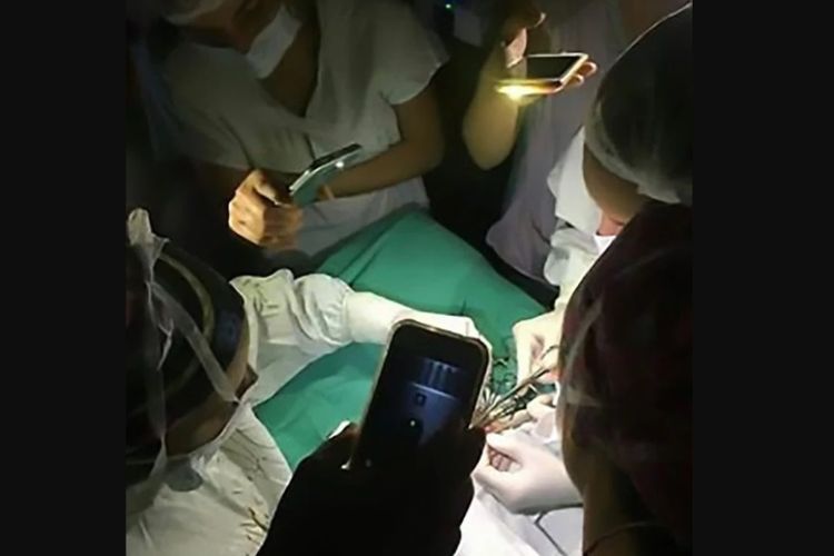 Sejumlah dokter bekerja sama menerangi meja operasi menggunakan lampu ponsel saat terjadi listrik padam di rumah sakit di Argentina.