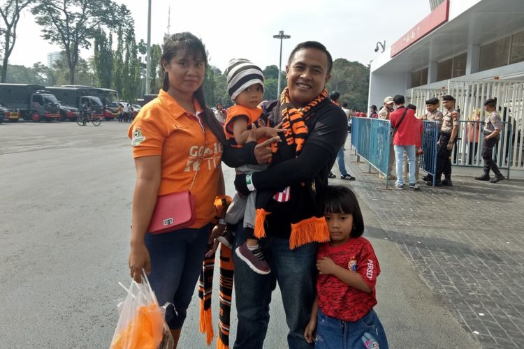 Iwan (31), salah satu The Jakmania asal Kalideres, Jakarta Barat yang membawa anak dan istrinya menyaksikan laga Persija vs Persib Bandung di Stadion Utama Gelora Bung Karno, Jakarta, Rabu (10/7/2019).