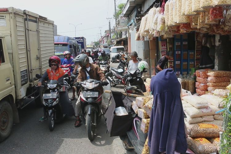 Sejumlah kendaraan roda dua dan empat melintas sekitar kawasan Pasar Kue Weru, Desa Weru, Kecamatan Weru, Kabupaten Cirebon, Jawa Barat, Selasa (14/5/2019). Pasar tradisional ke empat yang mayoritas menjual jajanan kering ini juga berpotensi menjadi titik hambatan para pemudik. 