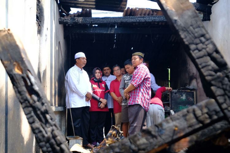 Mulyono (kemeja kotak-kotak) dan Wali Kota Magelang Sigit Widyonindito saat melihat kondisi rumah pasca musibah kebakaran, Jumat (13/4/2018). Musibah terjadi pada Kamis (12/4/2018), mengakibatkan istri Mulyono meninggal dunia. 